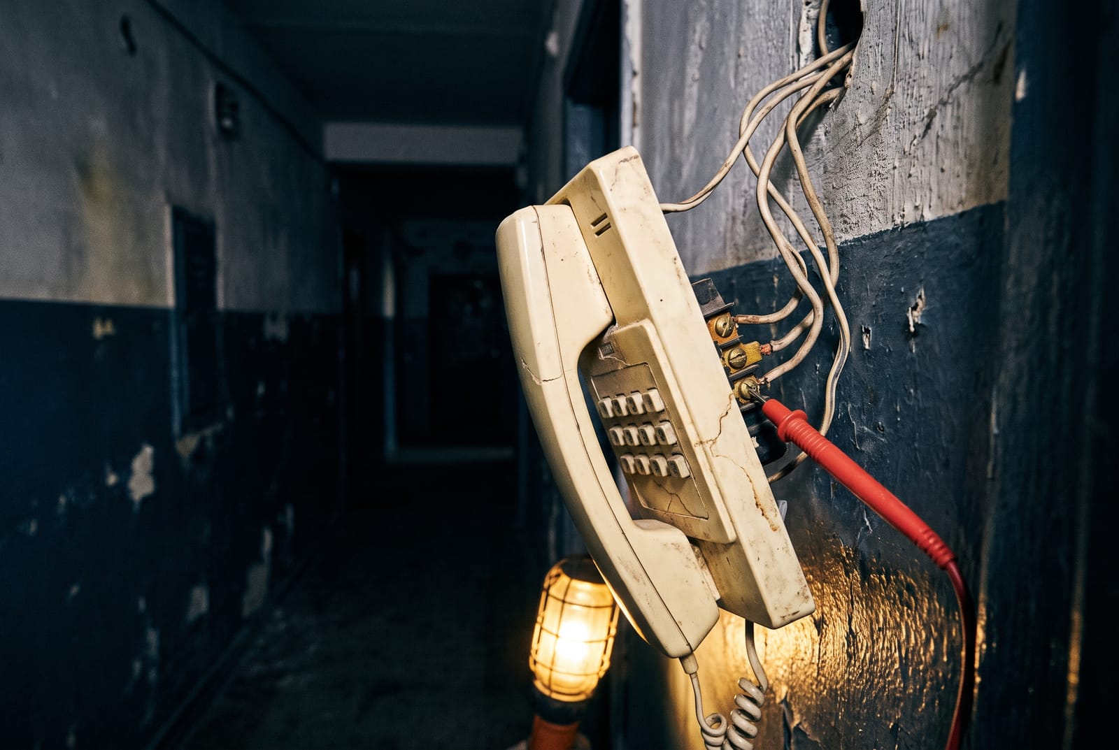 An open legacy intercom amplifier cabinet in a basement, terminal strips exposed, with decades of added and abandoned wiring around it